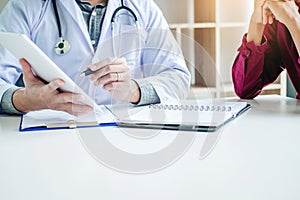 Doctors and patients sit and talk. At the table near the window in the hospital