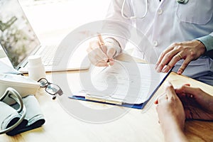 Doctors and patients sit and talk to the patient about medication. At the table near the window in the hospital.