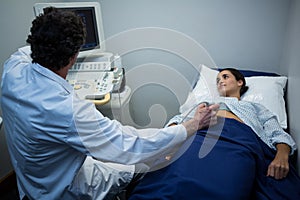 Doctors performing a doppler sonography on patient stomach