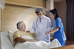 Doctors and physical therapists are caring for elderly sick people.  Woman holding tablet computer