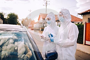 Doctors in a protective suit taking swab from a person to test for possible coronavirus infection