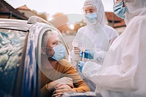 Doctors in a protective suit taking swab from a person to test for possible coronavirus infection