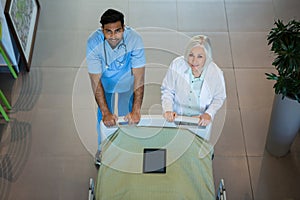 Doctors pushing emergency stretcher bed in corridor