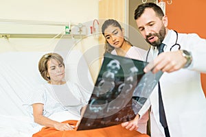 Doctors Showing Xray To Patient At Hospital