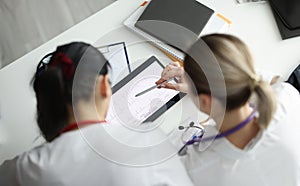 Doctors studying electrocardiogram on digital tablet closeup