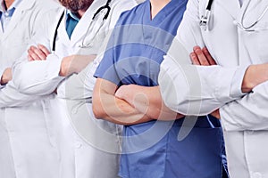 Doctors and surgeons in healthcare team with arms crossed in a row in hospital