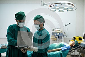 Doctors or surgeons with Physician assistant standing to discussion about a patient case in an operating room before performing