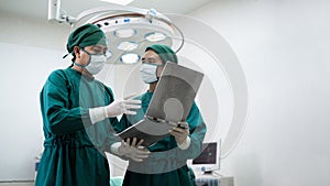 Doctors or surgeons with Physician assistant standing to discussion about a patient case in an operating room before performing