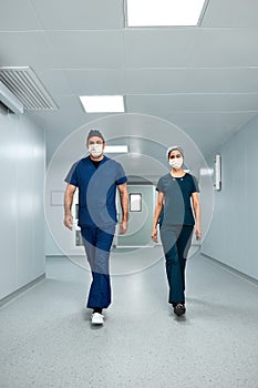 Doctors surgeons walk along the corridor of the clinic in suspense, preparing for a complex operation.