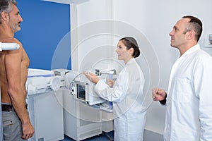 Doctors taking upright x-ray mans abdomen