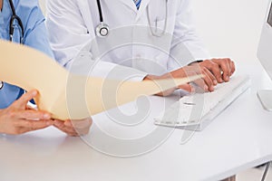 Doctors using computer looking at files