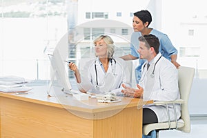 Doctors using computer together at medical office