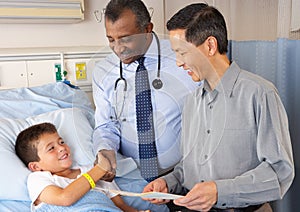 Doctors Visiting Child Patient On Ward photo