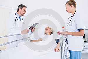 Doctors visiting a female patient in hospital