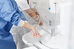 Doctors washing hands using disinfecting liquids in a surgical clinic