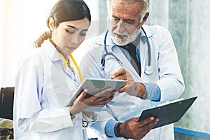 Doctors working with tablet computer at hospital.