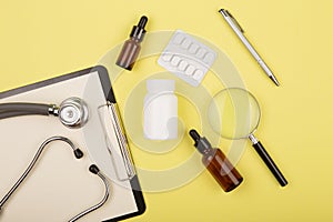 doctors workplace - medical tablet, stethoscope, pills and magnifying glass