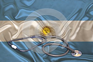 Doctorâ€™s tool, medical stethoscope, lies on the silk national flag of the modern state of Argentina, concept of tourism,