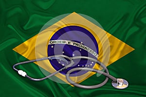 Doctorâ€™s tool, medical stethoscope, lies on the silk national flag of the state of Brazil, the concept of tourism, insurance,