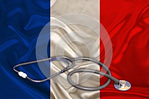 Doctorâ€™s tool, medical stethoscope, lies on the silk national flag of the state of France, the concept of tourism, insurance,