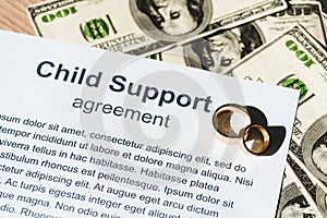 Document with child support agreement near dollar banknotes