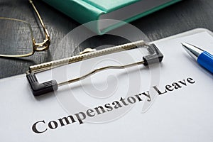 Document about Compensatory leave and pen for signing.