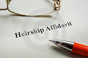 Document about heirship affidavit, glasses and pen.