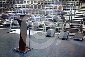 Document stand on black stage and rows of seats in