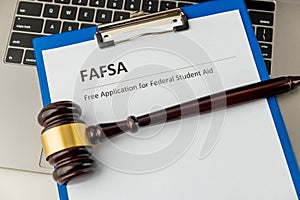 Document with student aid and wooden gavel on the table with laptop isolated. Fafsa