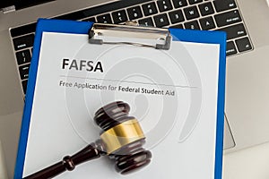 Document with student aid and wooden gavel on the table with laptop isolated. Fafsa