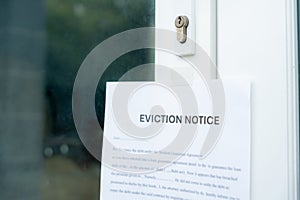 document with the text eviction notice, Civil servant sticks a notice of eviction of the tenants hangs on the door of the house,