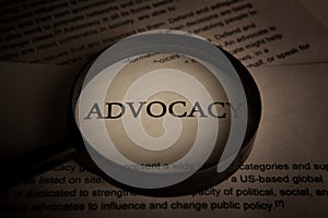 Document with the title of advocacy under a magnifying glass