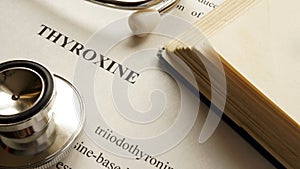 Document with title Thyroxine on a table.