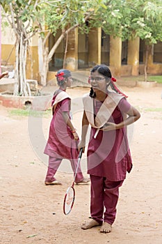 Documentary editorial image. Active indian preschool girl and boy playing badminton in outdoor court in summer. School sports for