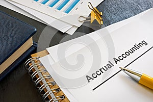 Documents about accrual accounting near notepad and pen.