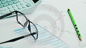 Documents with calculator. Printed stock graphs and charts. Analyzing financial data report and business concept. Profit