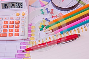 The documents painted colorful graphics. Above lies the pen, pencil, magnifier and calculator