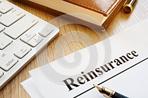 Documents with title reinsurance on a desk.