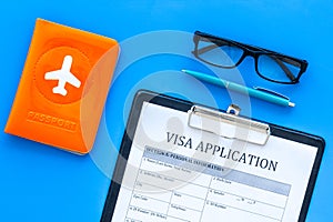 Documents for travel abroad. Visa application form, pen, passport cover with airplane silhouette on blue background top