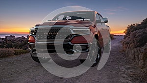 Dodge RAM 1500 driving a scenic road by the sea during a beautiful sunrise