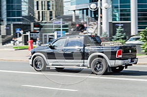 Dodge Ram 1500 Fourth generation is driving on street in centre of city with blurred background