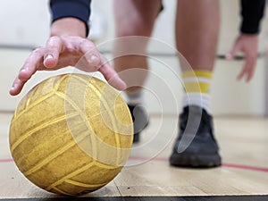 Dodgeball player picking up a yellow dodge ball