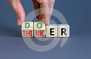 Doer or thinker symbol. Concept words Doer or thinker on wooden cubes. Businessman hand. Beautiful grey table grey background.