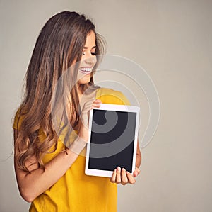 It does a pretty good job of keeping us all aligned. Shot of an attractive young woman holding a digital tablet with a