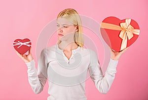 Does size really matter. Woman hold big and little heart shaped gift boxes. Which one she prefer. Girl decide which gift