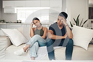 Doesnt look like either of them will apologise. a young couple ignoring each other after an argument at home.