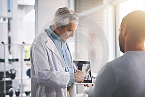 It doesnt look too bad. a senior doctor giving his male patient a thorough checkup during his consultation.