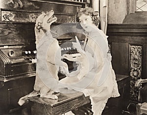 Dog accompanying woman on piano