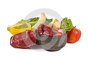 Dog bowl filled with biologically appropriate raw food containing meat chunks, fruits and vegetables photo