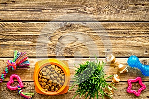 Dog or cat food in bowl with treats and toys, top view